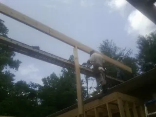 Carpenter setting a ridge beam over a new addition frame — Ice Dam Removal by Roofing Brothers in Manitou Springs