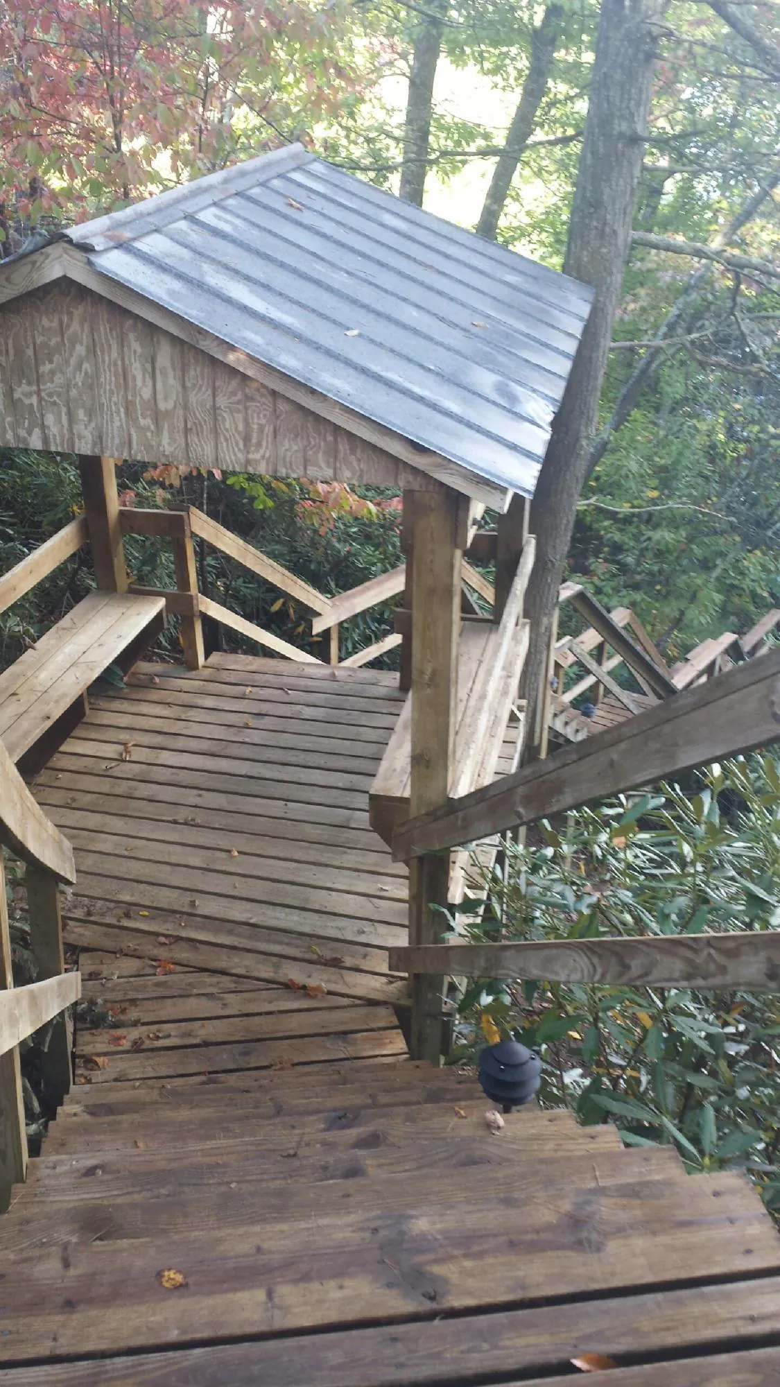 Metal roofed shelter over wooden steps on a wooded walkway — Skylight Repair & Installation work by our crew in Manitou Springs