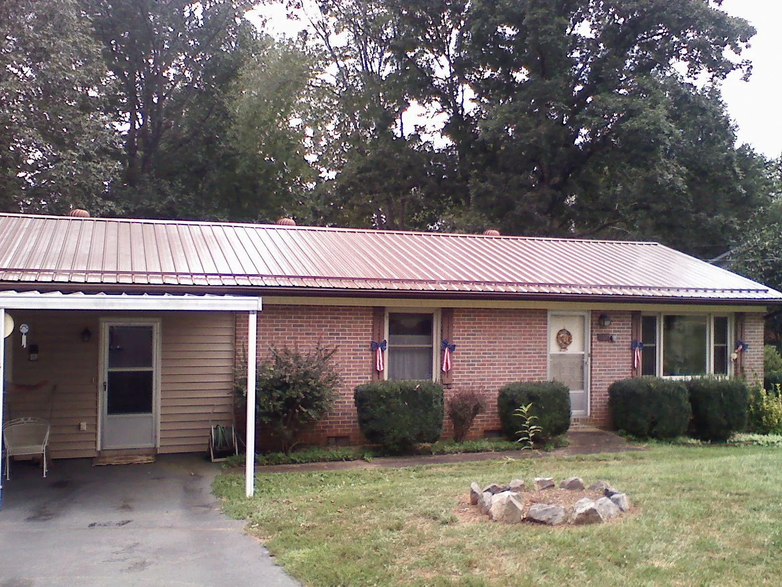 Bronze metal roof and carport on a brick ranch home — Roof Repair work by our crew in Manitou Springs